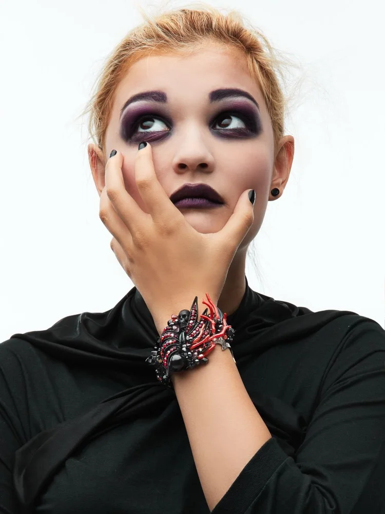 Dark makeup and an Andrea Li red and black cluster cuff