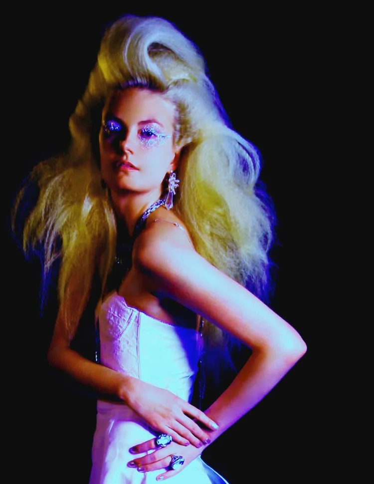 Big blonde hair under colored light, Andrea Li crystal earring and ring