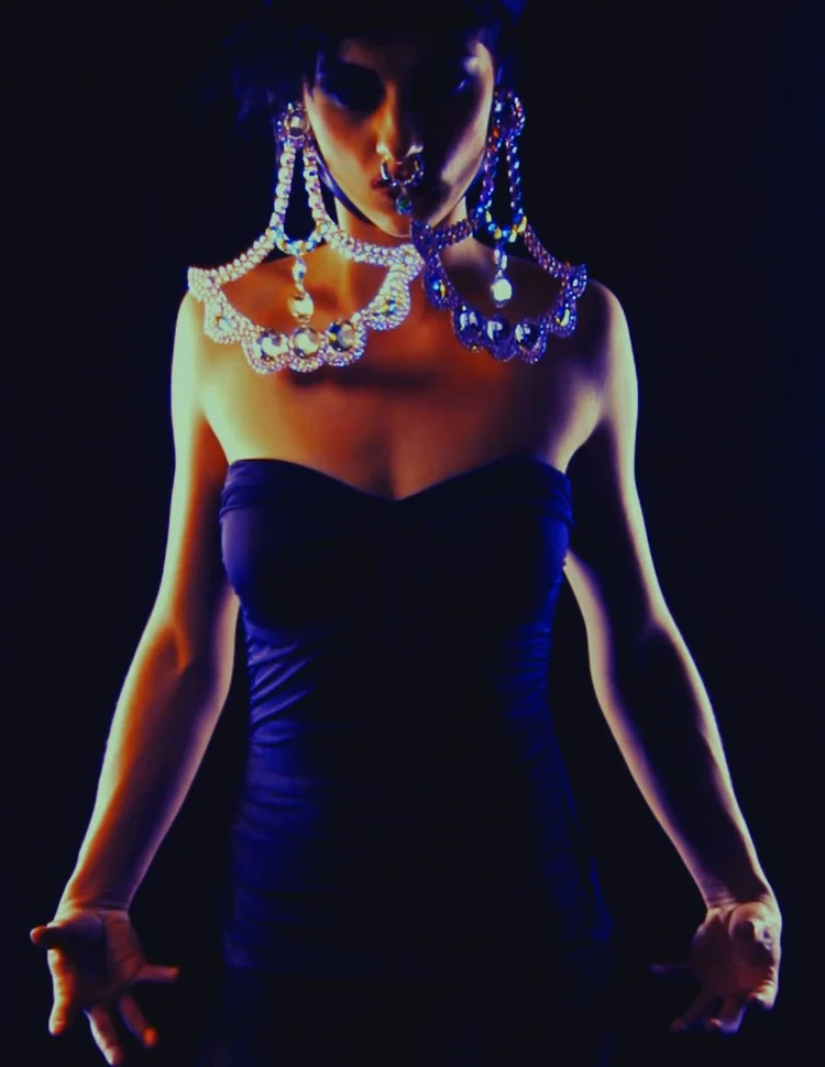 A model with large Andrea Li crystal swag earrings and shoulder piece