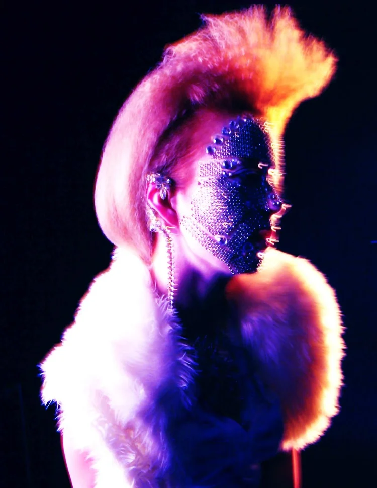 A pink mohawk, a crystal face mask and fur