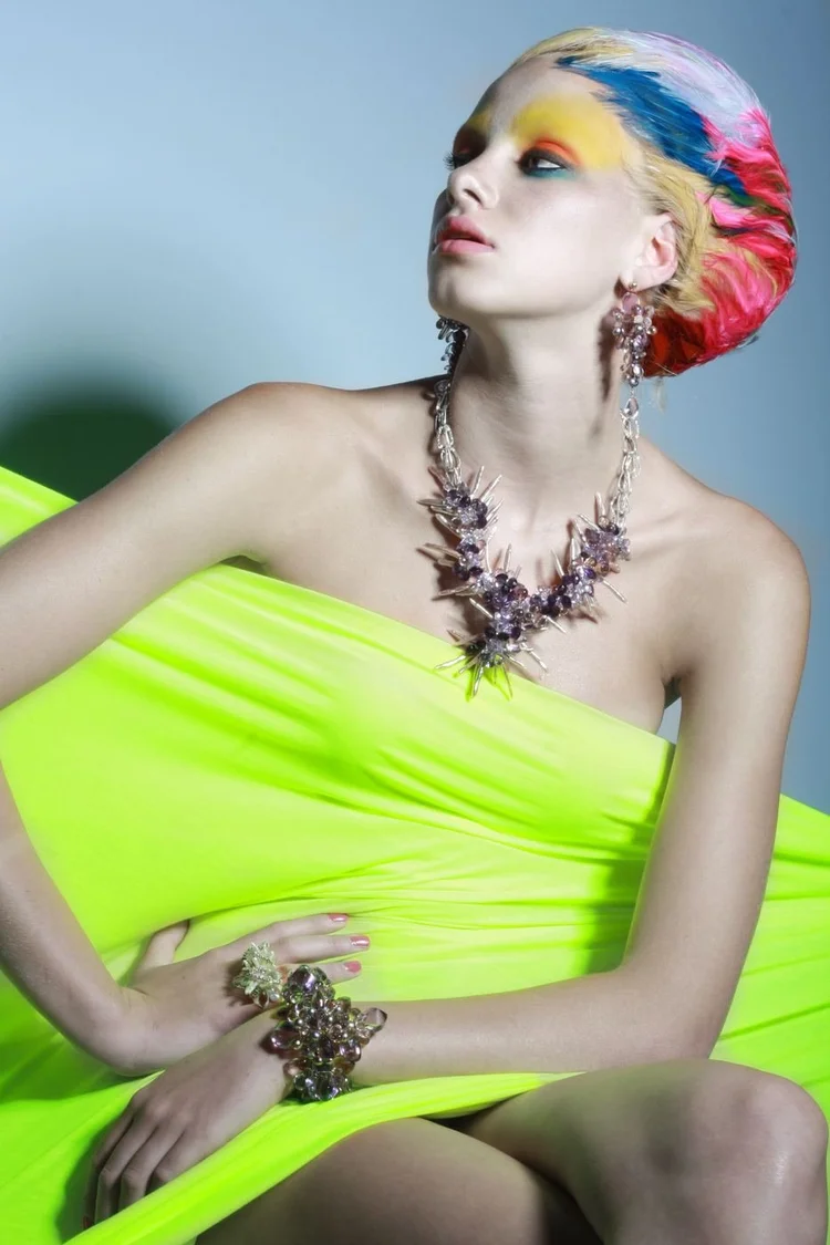 A model in a neon green drape with an Andrea Li wire cluster necklace and cuff