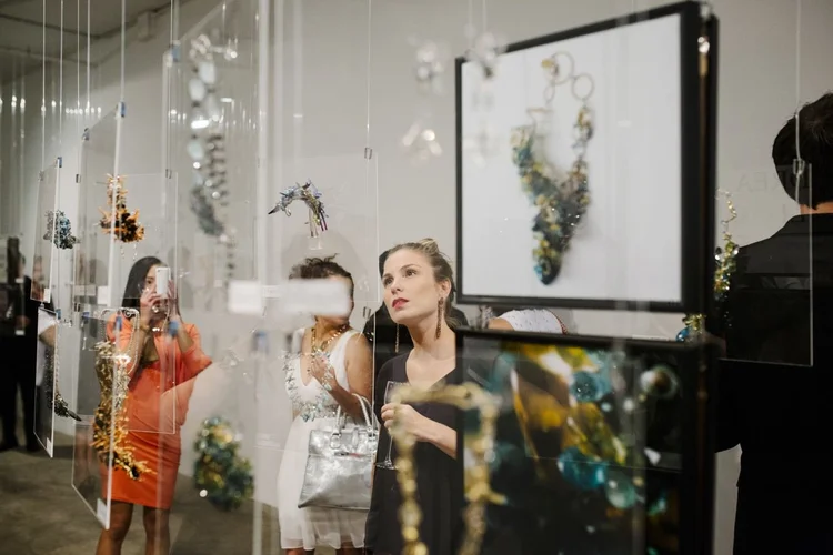 Guests beside the framed print of an Andrea Li blue cluster necklace