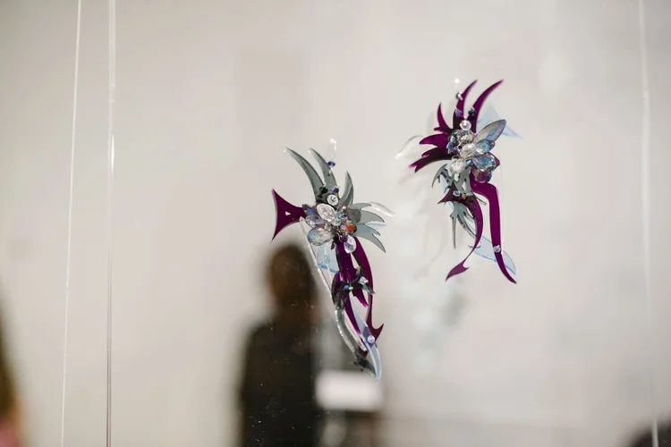 Two Andrea Li iridescent purple spiked pieces hanging in the gallery