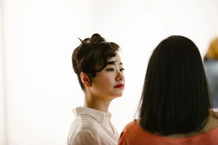 A guest in a white shirt and pearls at the show