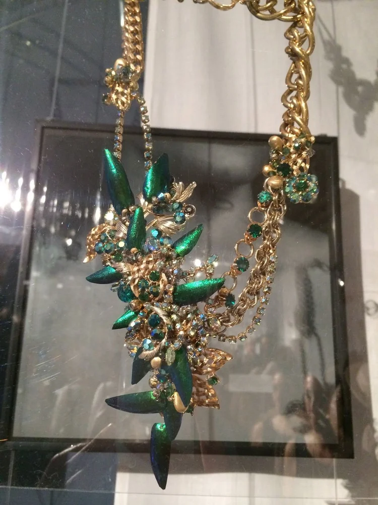 An Andrea Li gold chain necklace with a green iridescent beetle-wing cluster