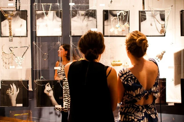 Guests at the 2014 opening among hanging clear panels and framed photographs of hands