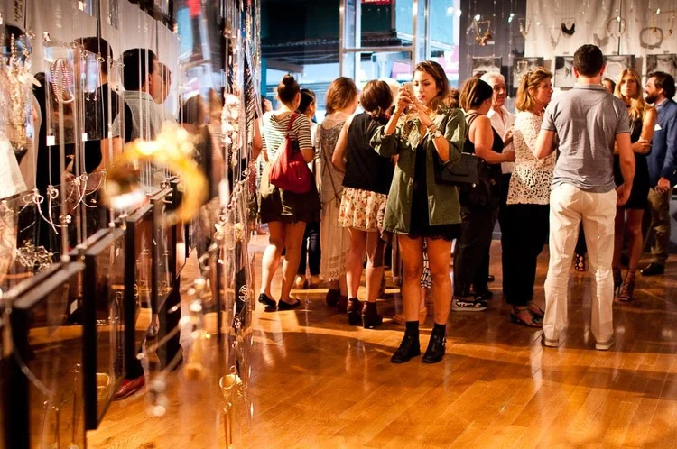 Guests at the 2014 opening among hanging clear panels and framed photographs of hands