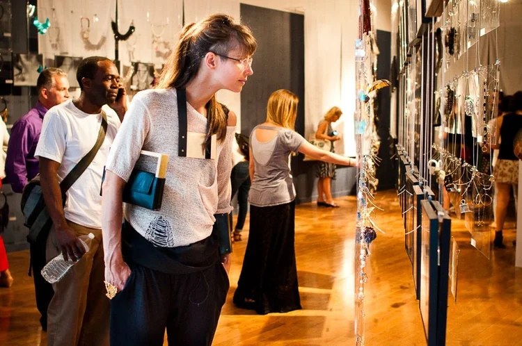 Guests at the 2014 opening among hanging clear panels and framed photographs of hands