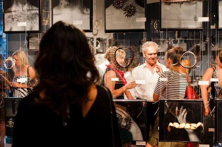 Guests at the 2014 opening among hanging clear panels and framed photographs of hands
