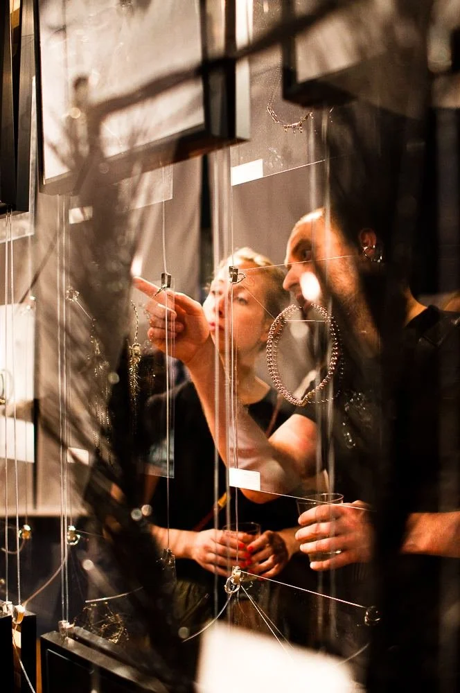Guests at the 2014 opening among hanging clear panels and framed photographs of hands
