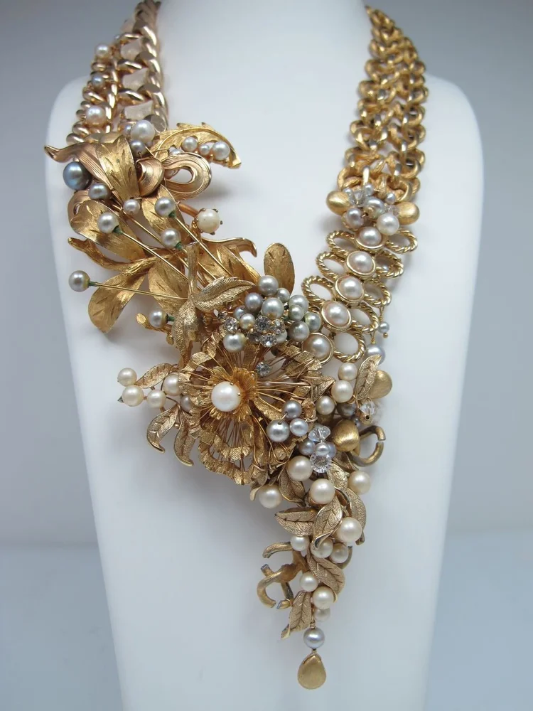 Studio photo on a bust: a gold chain necklace with gold leaf and pearl cluster