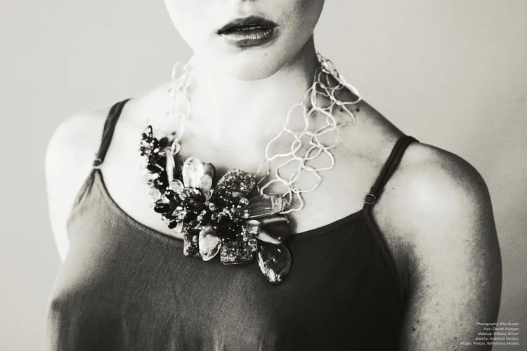 Black and white: a model in a dark tank top wearing a large Andrea Li floral cluster statement necklace