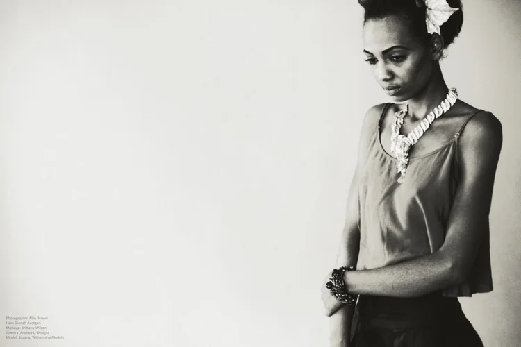 Black and white: a seated model in a silk camisole with an Andrea Li bead cluster necklace and cuff