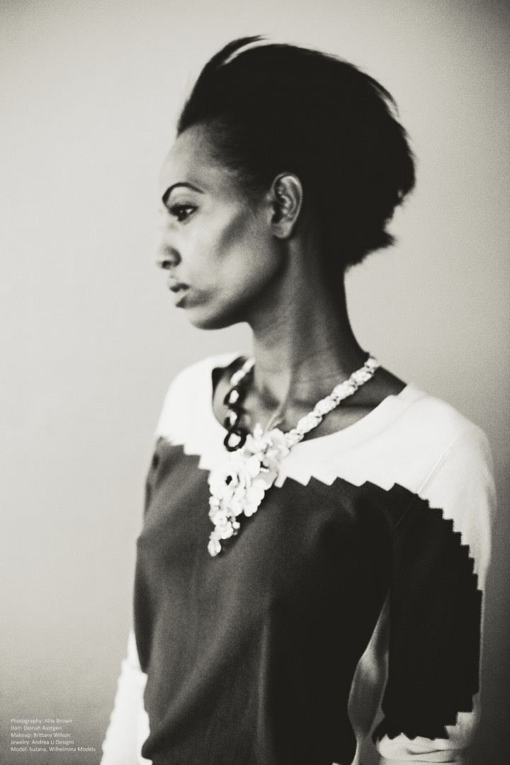 Black and white profile: a model in a zigzag sweater with an Andrea Li statement necklace