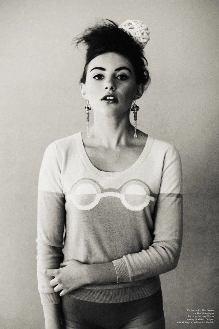 Black and white: a model in a sweater with a glasses motif and long Andrea Li drop earrings
