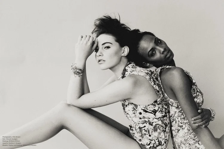 Black and white landscape: two models seated together in floral tops, Andrea Li cuffs