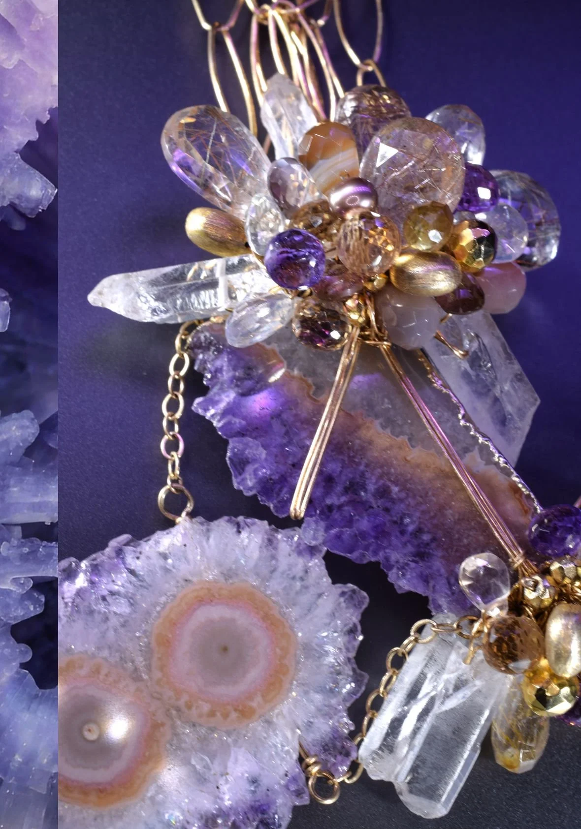 Close view of an Andrea Li amethyst stalactite necklace: two amethyst stalactite slices with crystal points and a cluster of amethyst, marble agate, rutilated quartz, champagne topaz and pyrite on gold chain
