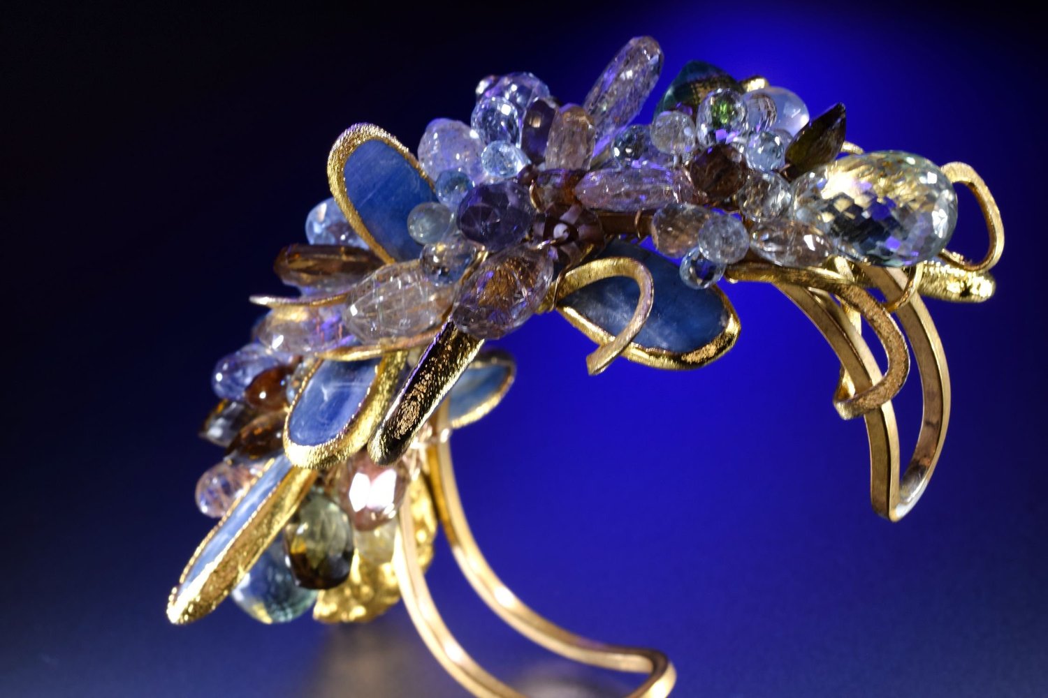 Andrea Li gilded statement cuff with kyanite and mixed gemstones on deep blue, by Andrea Li