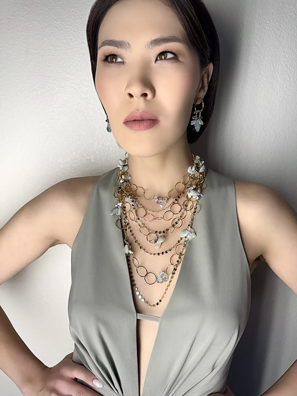 A model wearing an Australian opal and gemstone multi-chain necklace in gold, with earrings, by Andrea Li