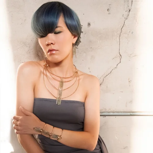 A model wearing a mid-length Andrea Li bib necklace with a strapless top