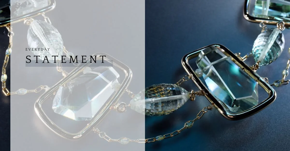 Split graphic with “Everyday Statement” text beside a close-up of a geometric gold necklace with clear blue gemstones on deep blue.