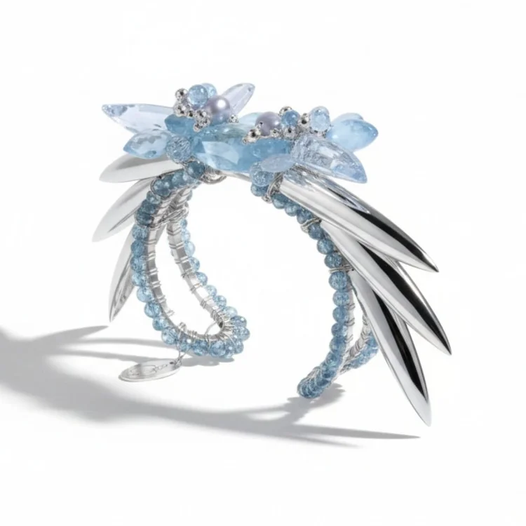 A silver cuff with blue gemstone clusters and sweeping silver blades