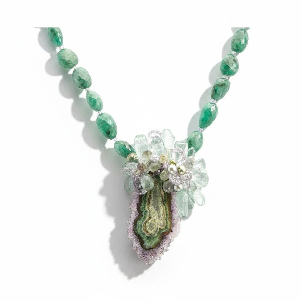 Statement necklace with green gemstone beads and a crystal slice pendant, arranged on a white background with soft shadow.