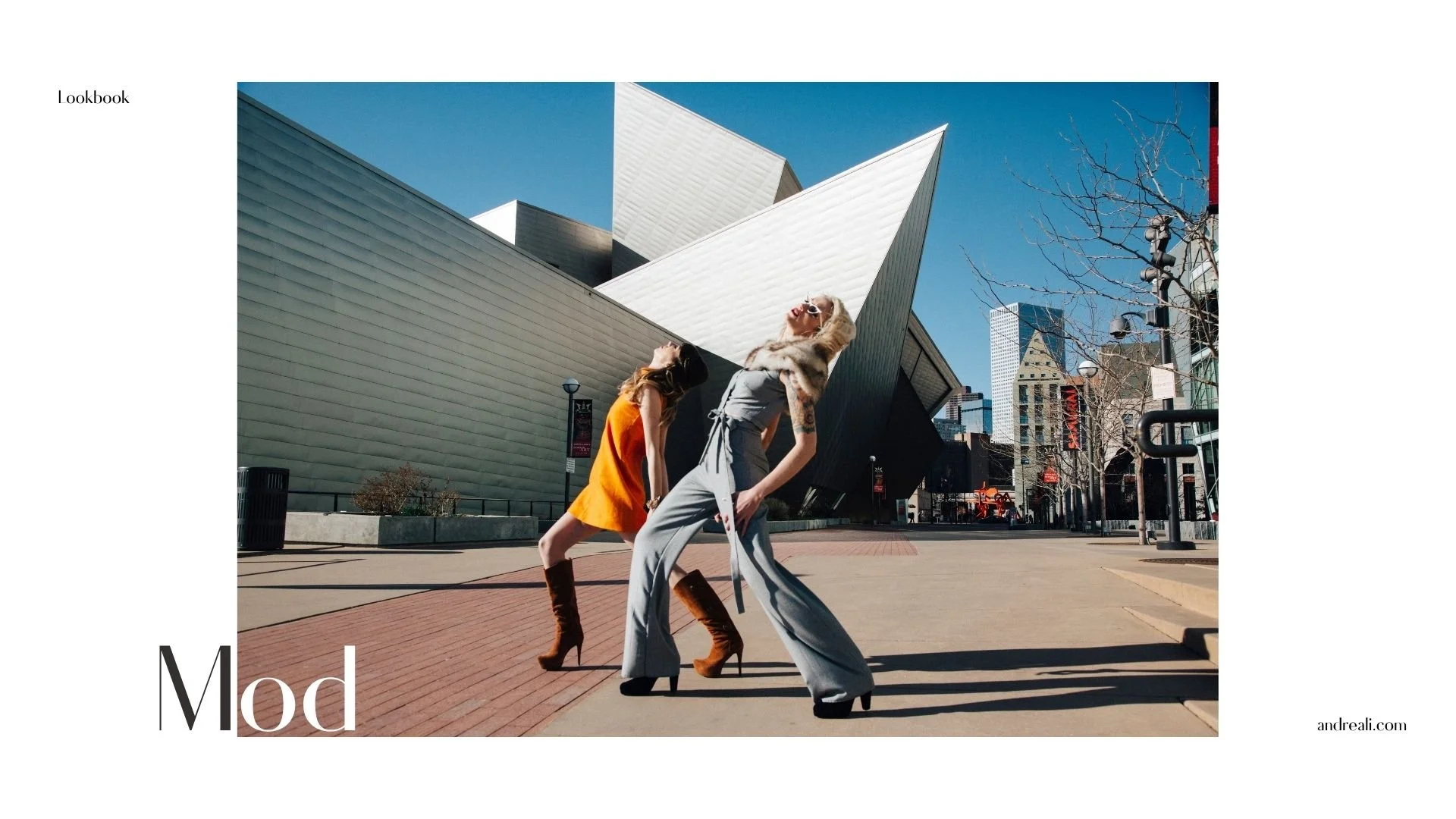 Lookbook cover featuring two fashion models posing in a city plaza beneath striking modern architecture and a bright blue sky.