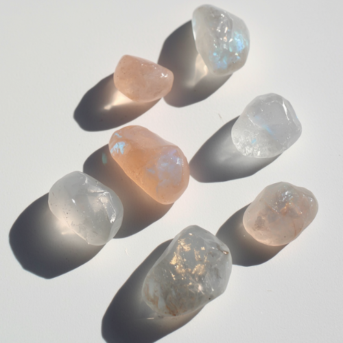 A group of moonstones: rainbow, peach, grey, and blue sheen