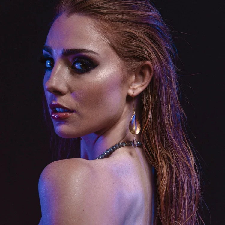 A model looking over her bare shoulder, wearing Andrea Li moonstone earrings, by Andrea Li