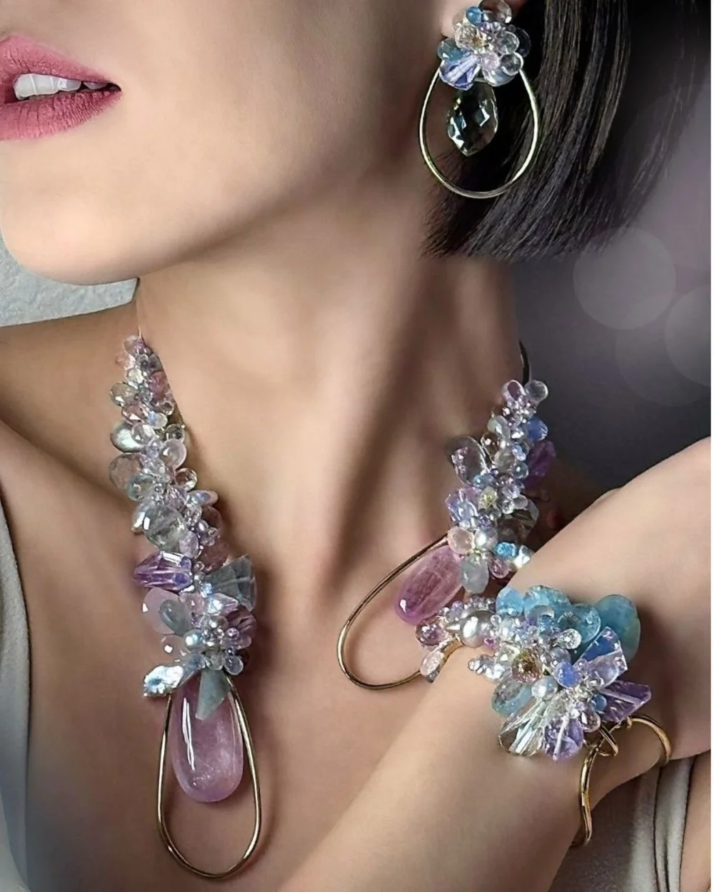 Close view of a model wearing an Andrea Li pastel gemstone cluster bracelet and a matching gemstone collar, by Andrea Li