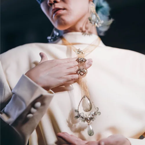 A model wearing an Andrea Li opera-length necklace below the bust