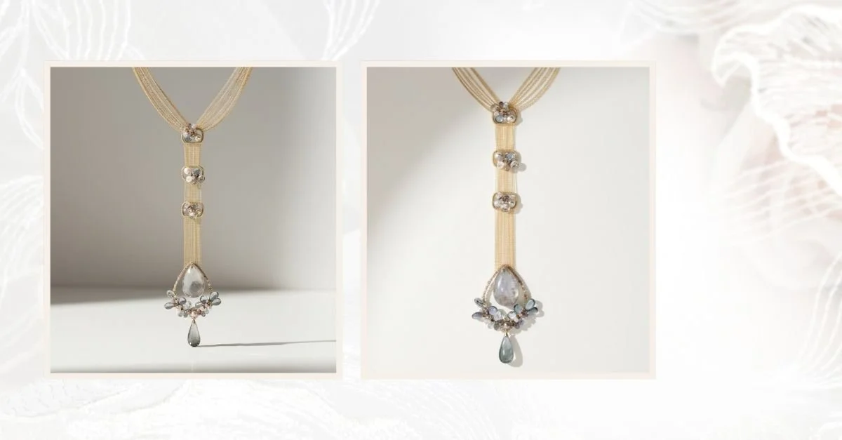 Side-by-side product photos of a long statement necklace with layered gold-toned strands, crystal accents, and a teardrop pendant with soft blue-gray gemstones, displayed against a light neutral background.