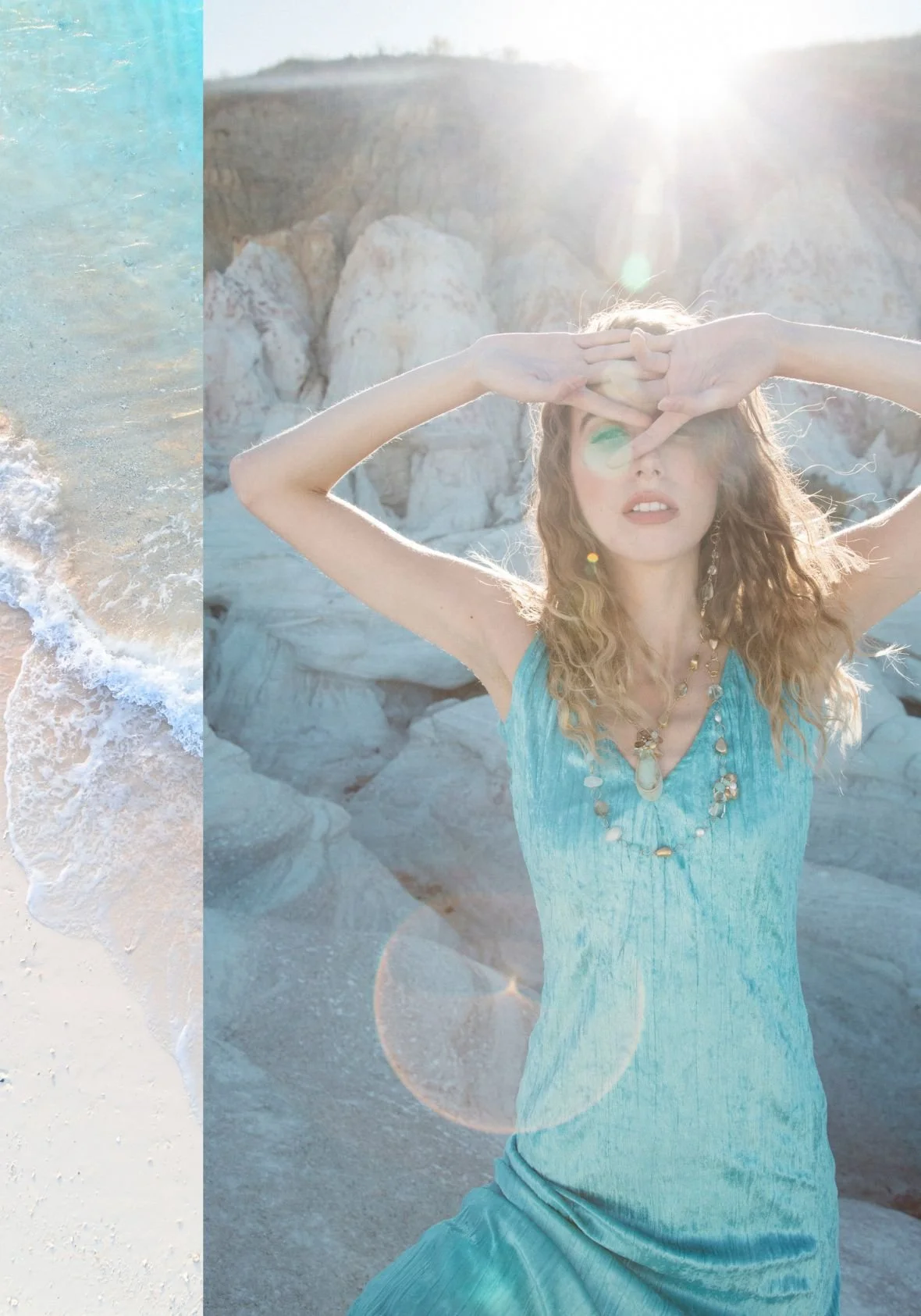 Sunlit portrait of a woman in a flowing turquoise dress and gemstone necklace, posing among white cliffs beside a beach strip.