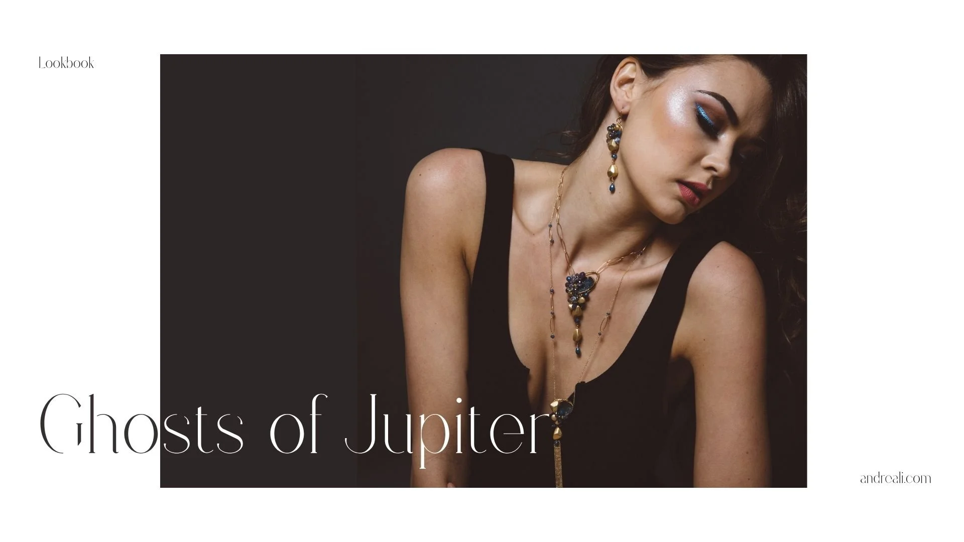 Lookbook cover for “Ghosts of Jupiter” featuring a moody portrait of a woman in a black dress wearing layered blue-and-gold statement jewelry and dramatic blue eye makeup.