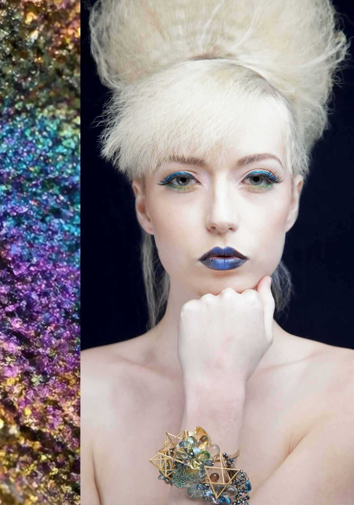 A model with a sculpted platinum updo wearing a gold cuff of open geometric stars clustered with green and blue gemstones