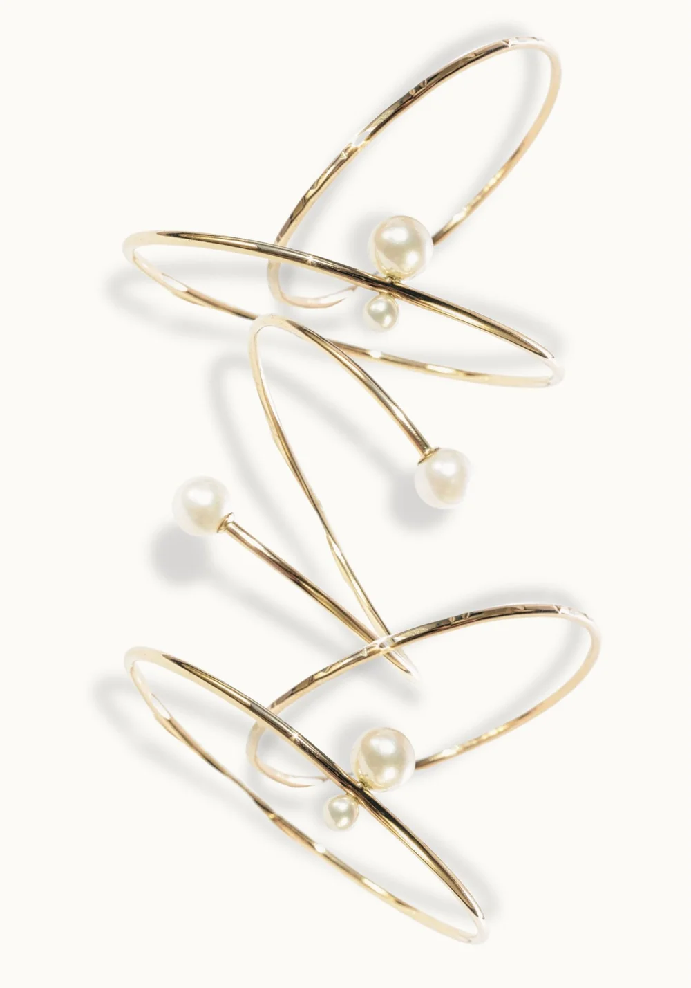 Three Andrea Li gold wire bangles with pearls, stacked
