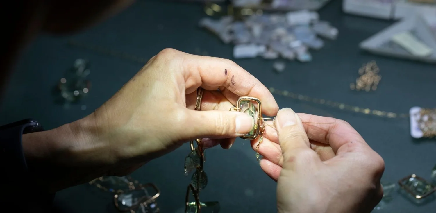 a pair of hands working at a jeweler's bench