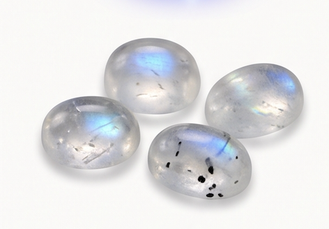 AA and A commercial grade rainbow moonstone cabochons with scattered blue flash and black speck inclusions