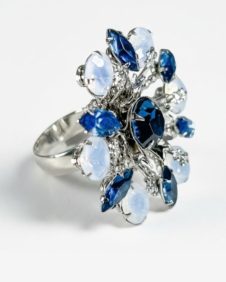 A custom Andrea Li cocktail ring with navy, periwinkle and opal-white gemstones on a silver band