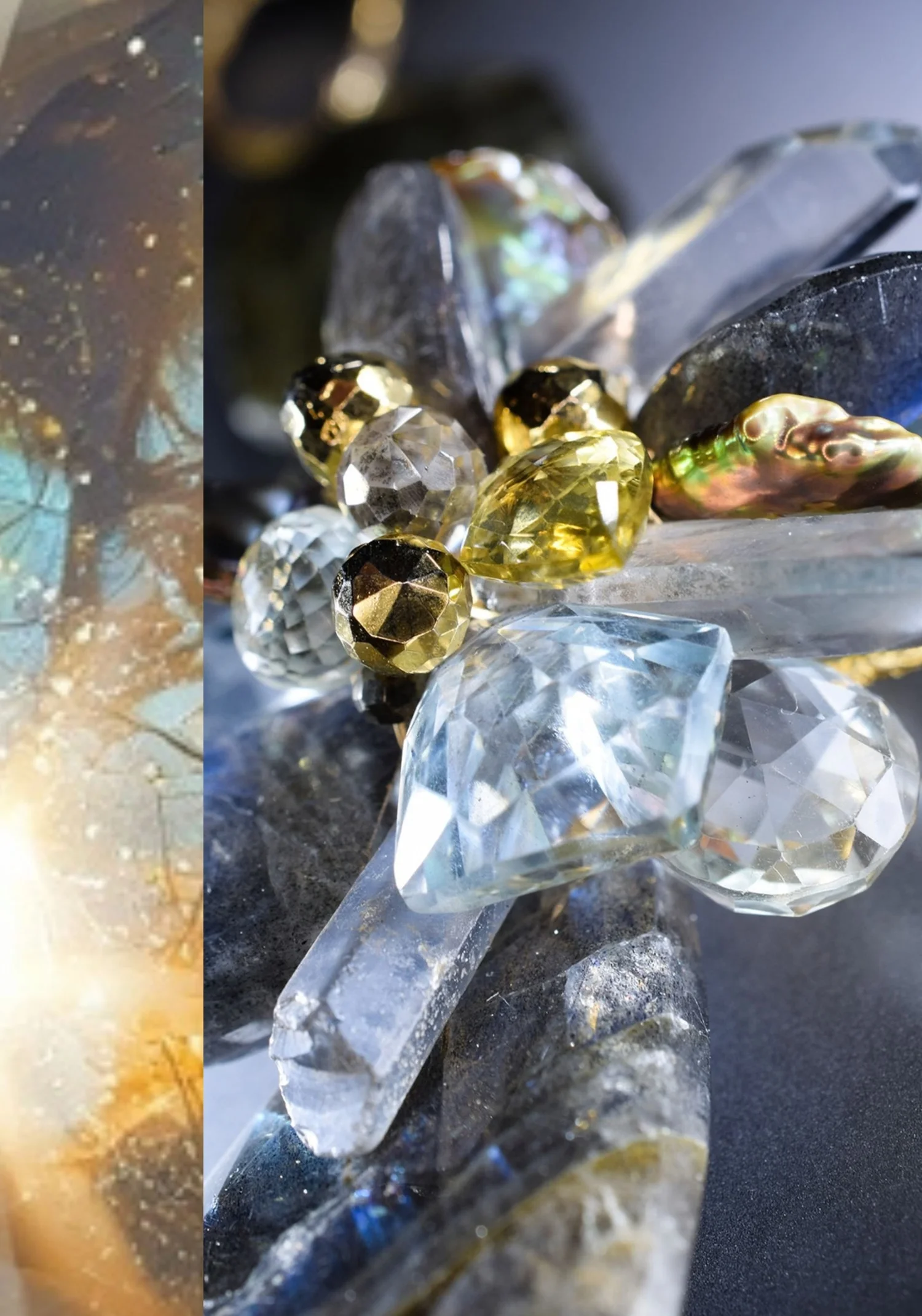 Close-up of a gemstone cluster of clear crystal points, faceted clear and yellow stones, gold beads and an iridescent pearl on a dark stone, beside a close-up of labradorite flashing blue and gold