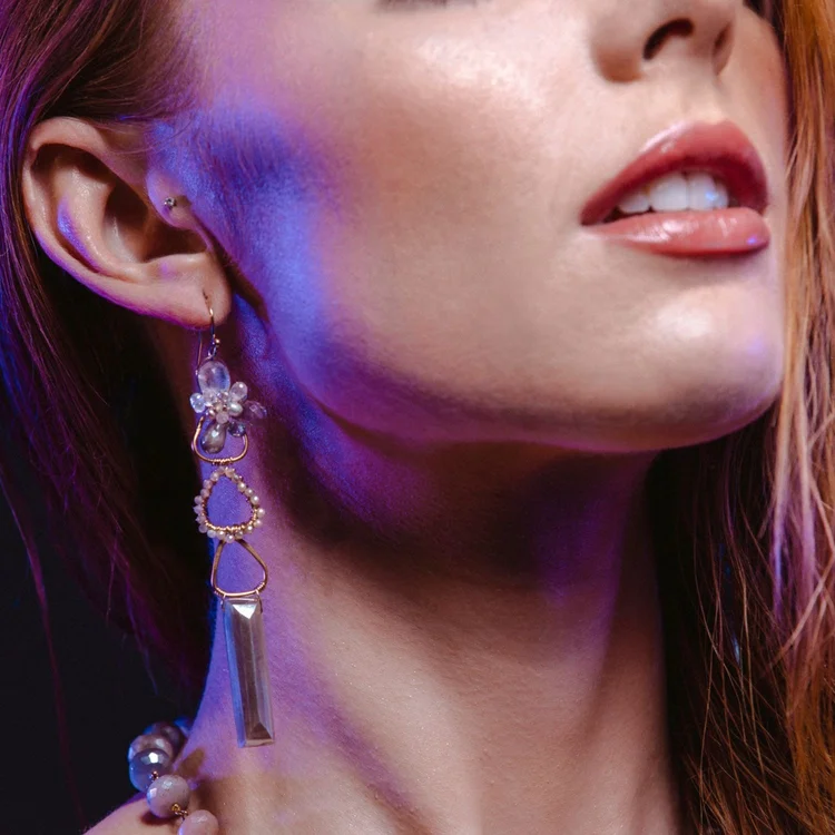 Close view of a model's jaw and ear with a long Andrea Li moonstone drop earring, by Andrea Li