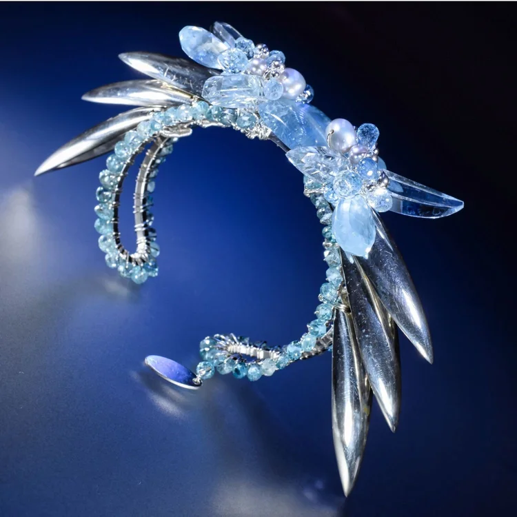 Andrea Li silver and aquamarine cuff with talon-like silver spikes on deep blue, by Andrea Li