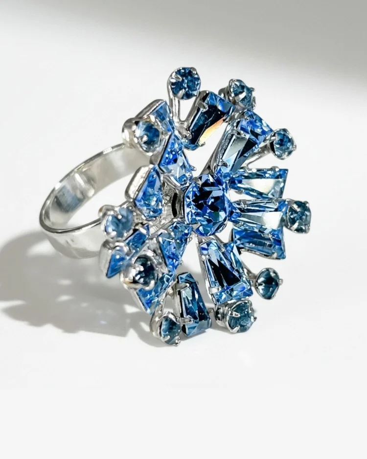 A custom Andrea Li cocktail ring: a starburst of blue gemstones on a silver band