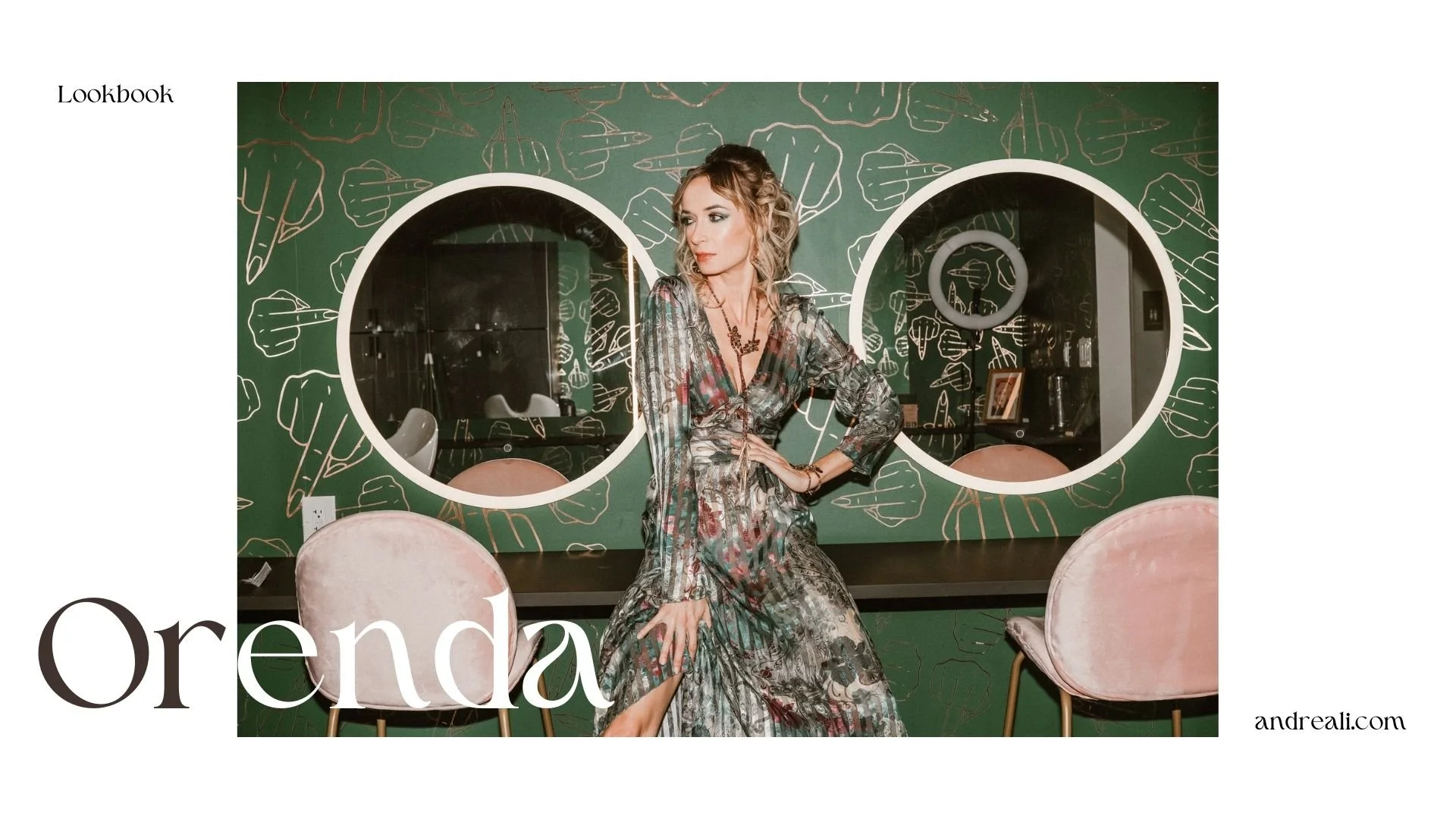 Lookbook cover for “Orenda” featuring a woman in a flowing patterned dress seated against a green illustrated wall with two round mirrors, blush velvet chairs, and “andreali.com” in the corner.