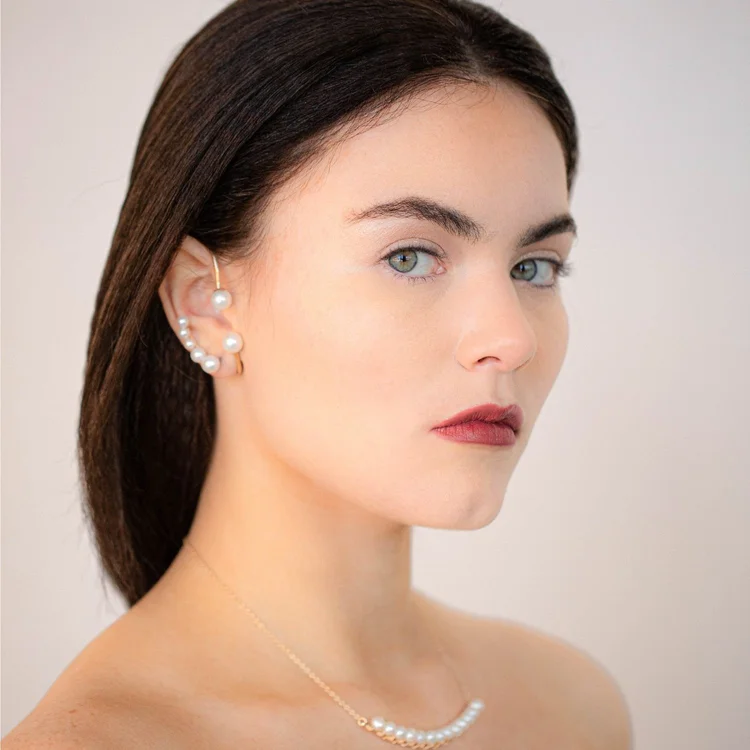 A model wearing an Andrea Li pearl ear climber and a delicate pearl necklace, by Andrea Li