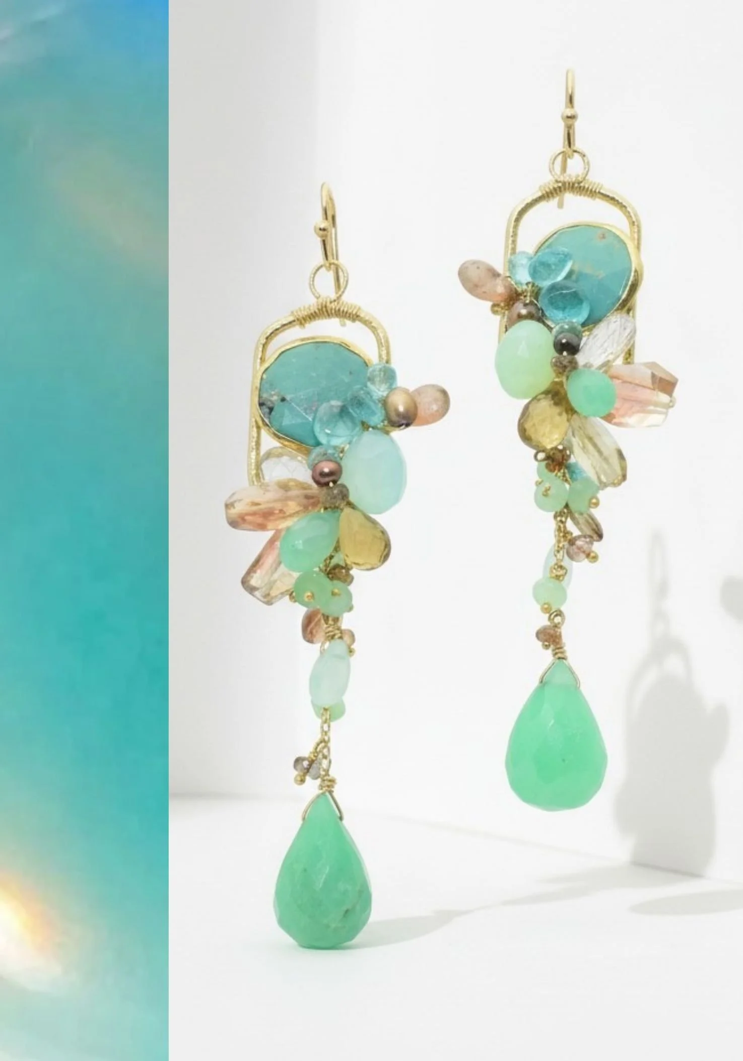 A pair of gold earrings clustered with blue, green and peach gemstones, each ending in a faceted green chrysoprase drop