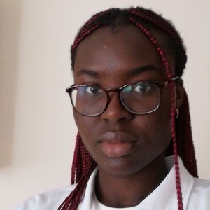 image of poet Faith Falayi, a young black woman with braided black hair wearing a white polo top and glasses 
