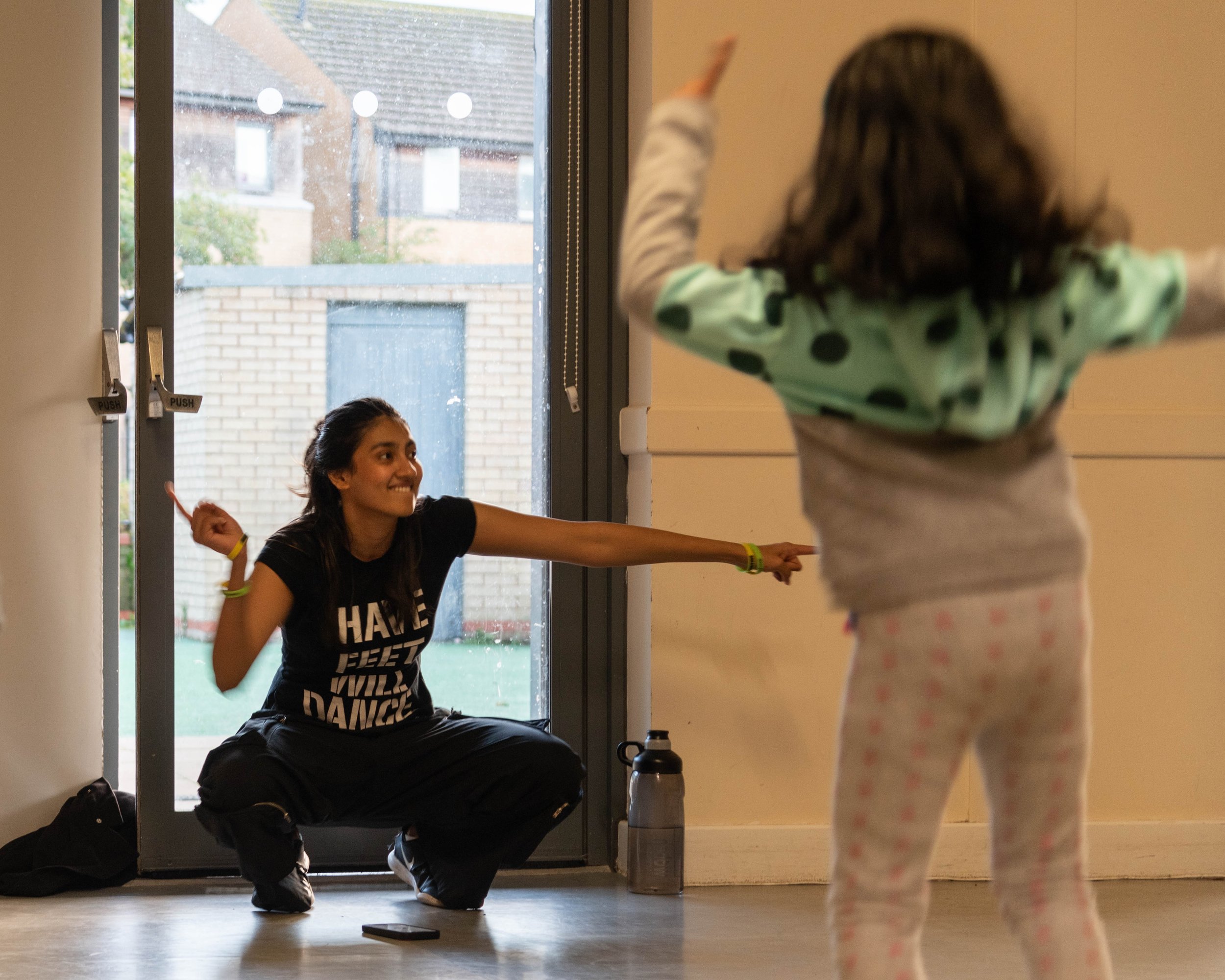  Neharika demonstrates Bollywood moves to a child in the class 