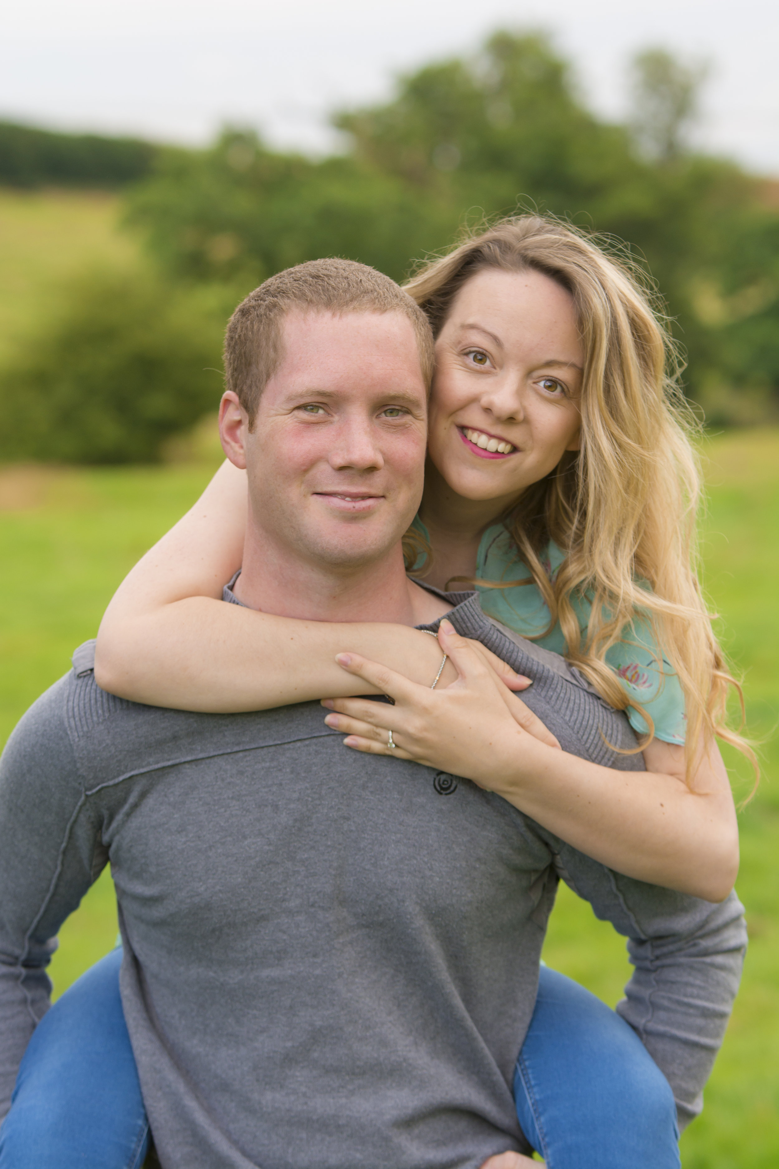 couple piggyback engagement outdoor photoshoot